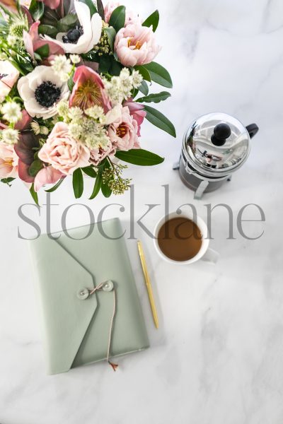 Vertical stock photo of green pocketbook and coffee