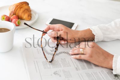 Horizontal stock photo of woman's hands and newpaper