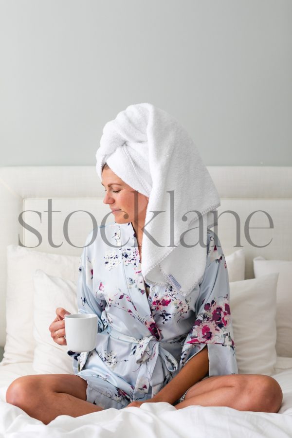 Vertical stock photo of woman in bathrobe having coffee