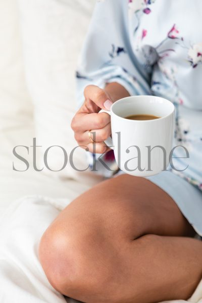 Vertical stock photo of woman in bathrobe having coffee