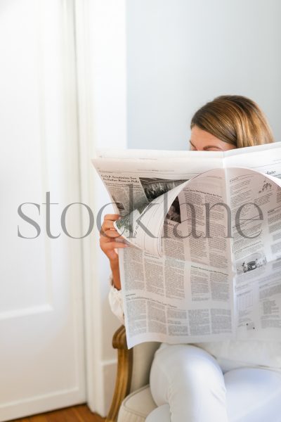 Vertical stock photo of woman reading the newspaper