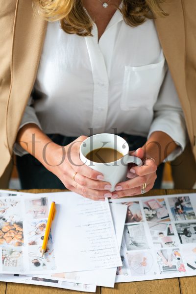 Vertical stock photo of woman with coffee cup working