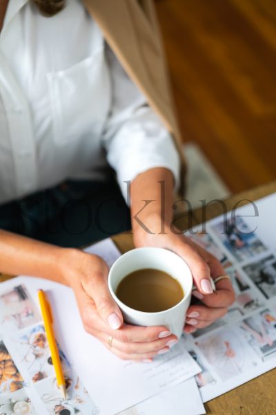 Vertical stock photo of woman with coffee cup working