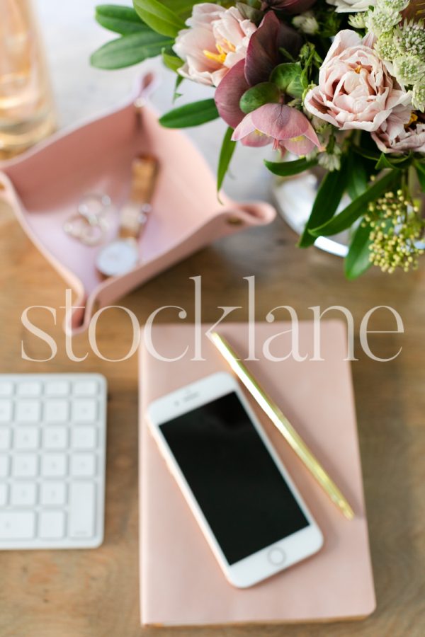 Vertical stock photo of desktop with pink accessories