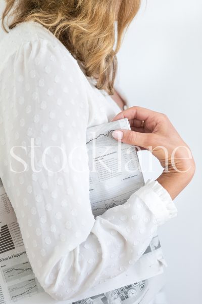 Vertical stock photo of woman holding newspaper