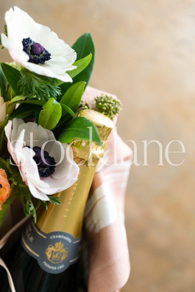 Vertical stock photo of flowers and champagne bottle