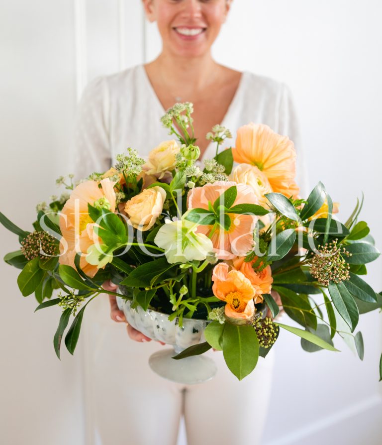 Vertical stock photo of woman with flower arrangement