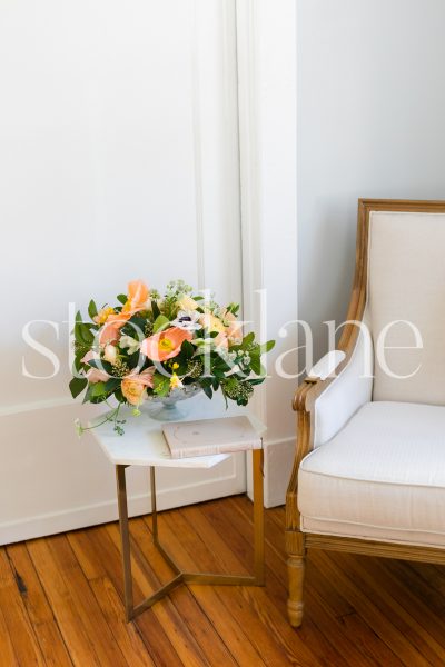 Vertical stock photo of reading chair and side table with flowers