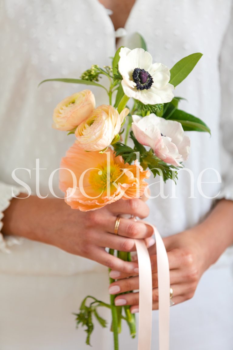 Vertical stock photo of woman holding floral arrangement