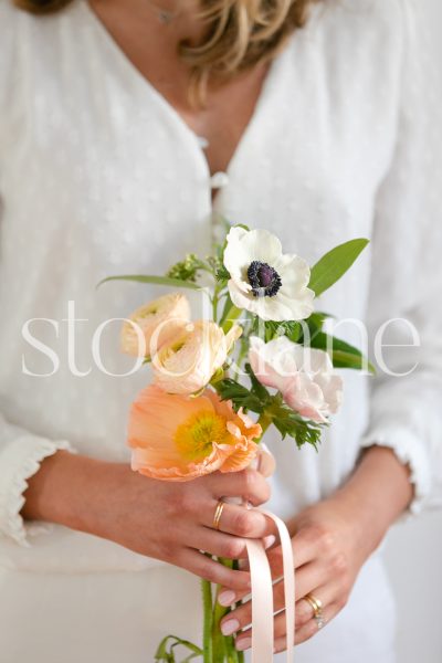 Vertical stock photo of woman holding floral arrangement