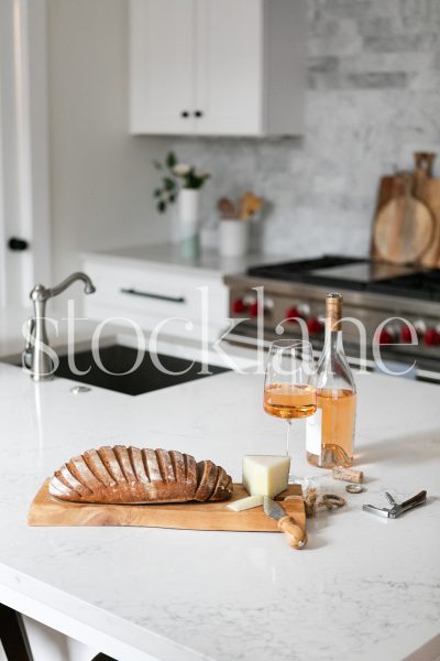 Vertical stock photo of bread and cheese board on kitchen counter