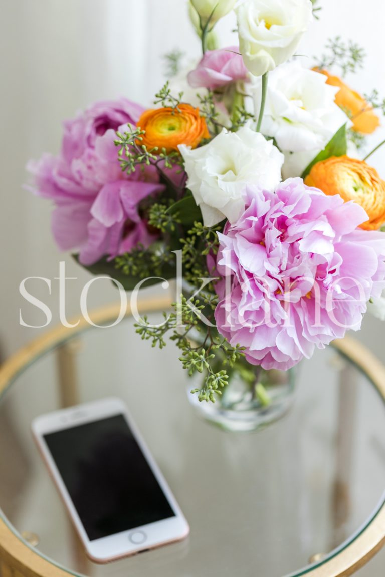 Vertical stock photo of phone on table with flowers