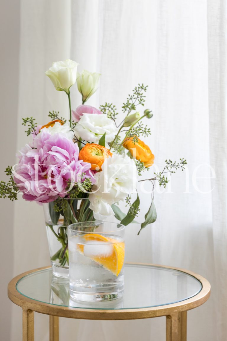 Vertical stock photo of table with cocktail and flowers