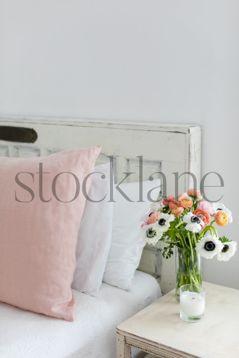 Vertical stock photo of feminine white and pink bedroom.