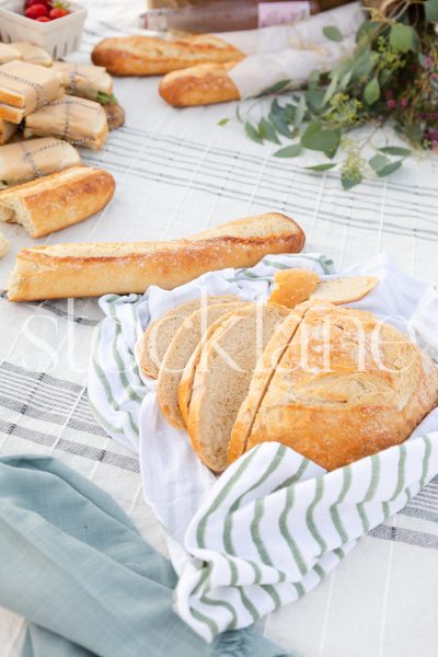 Vertical stock photo of bread at beach picnic.