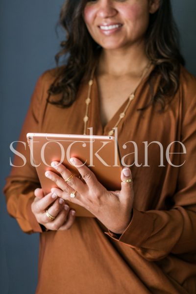 Vertical stock photo of woman holding an iPad.