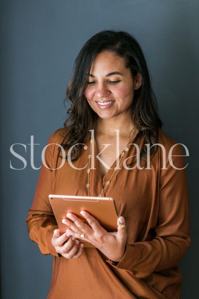 Vertical stock photo of woman holding an iPad.