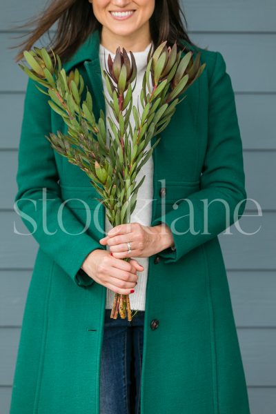 Vertical stock photo of a woman holding greenery