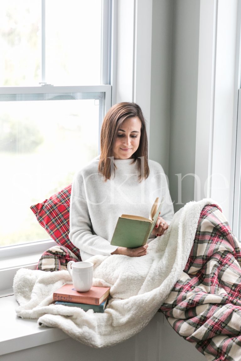 Vertical holiday stock photo of woman reading a book.