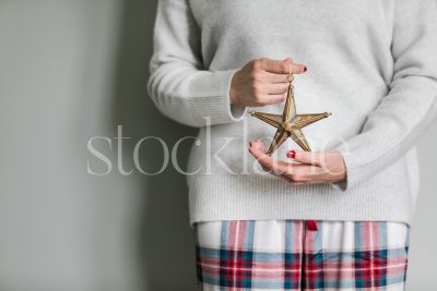 Horizontal holiday stock photo of a woman holding a star ornament.