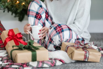 Horizontal stock photo of woman sitting next to Christmas presents.