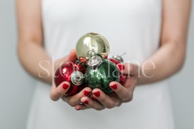 Horizontal stock photo of a woman in white dress with Christmas ornaments