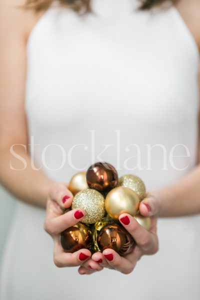 Vertical Stock photo of a woman in a white dress with Christmas ornaments