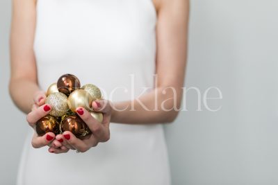 Vertical stock photo of a woman in a white dress with Christmas ornaments