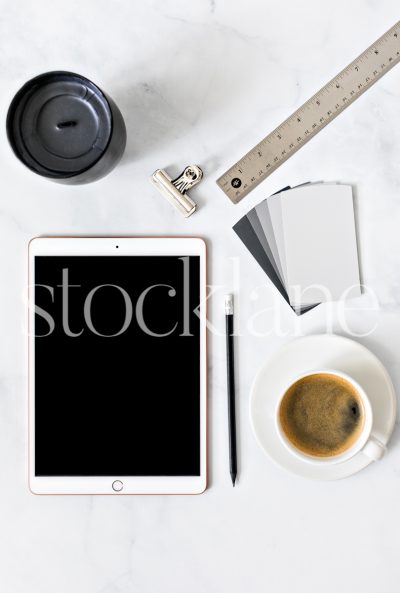 Vertical stock photo of a desktop with an iPad and a cup of coffee