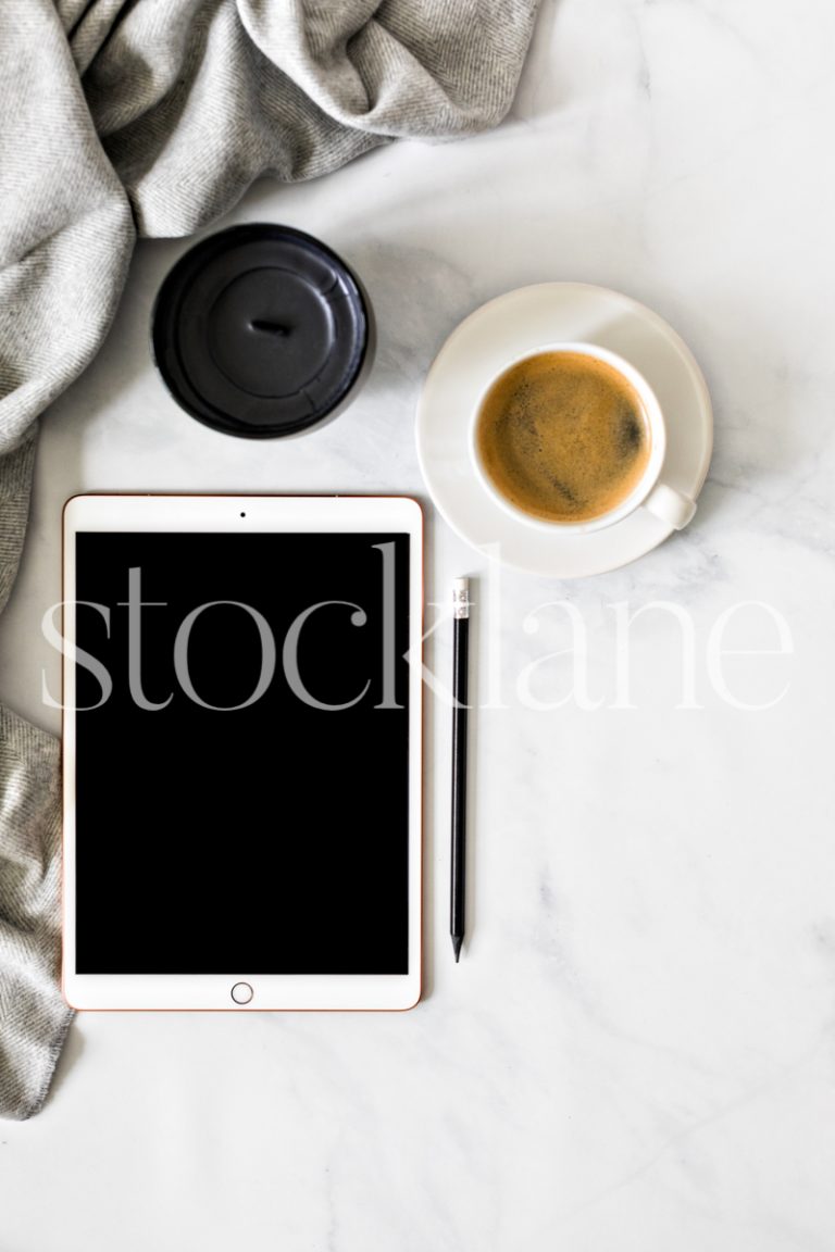 Vertical stock photo of a desktop with an iPad and a cup of coffee