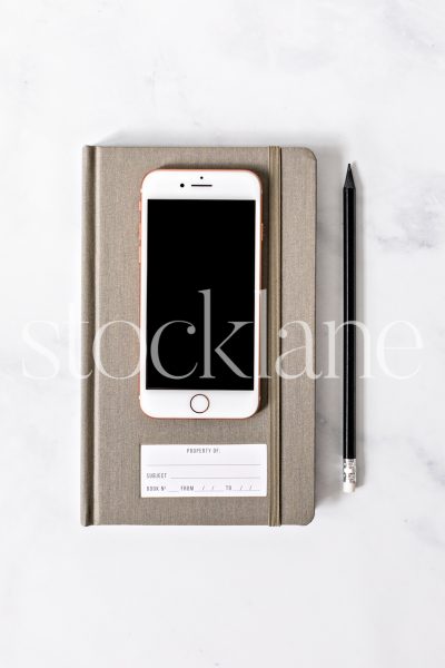 Vertical stock photo of a desktop with an iPhone