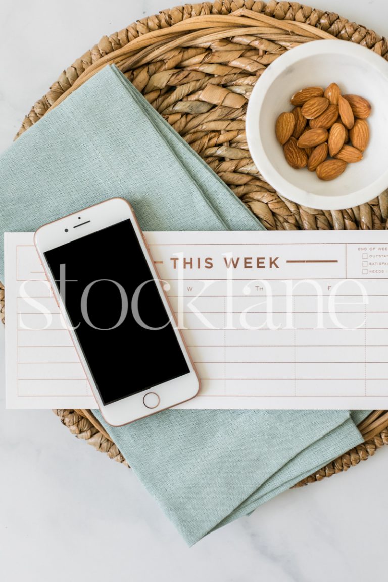 Vertical stock photo of a weekly planner and an iPhone