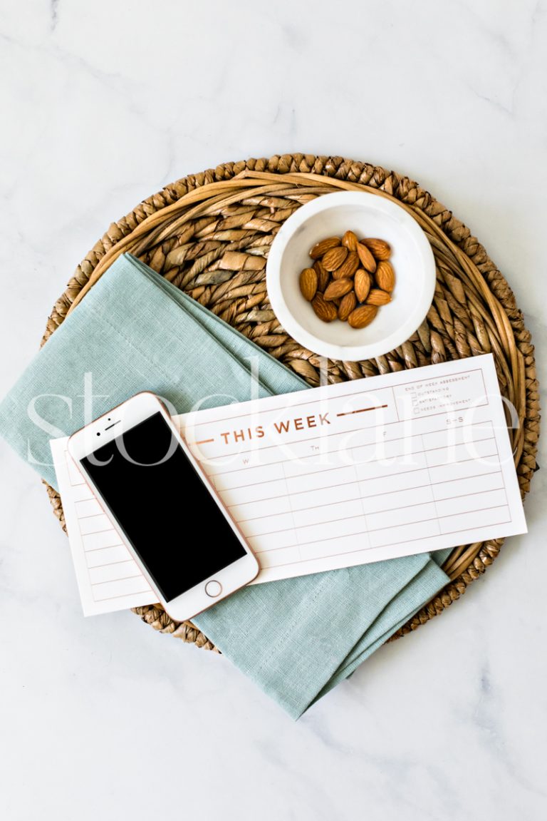 Vertical stock photo of a weekly planner and an iPhone