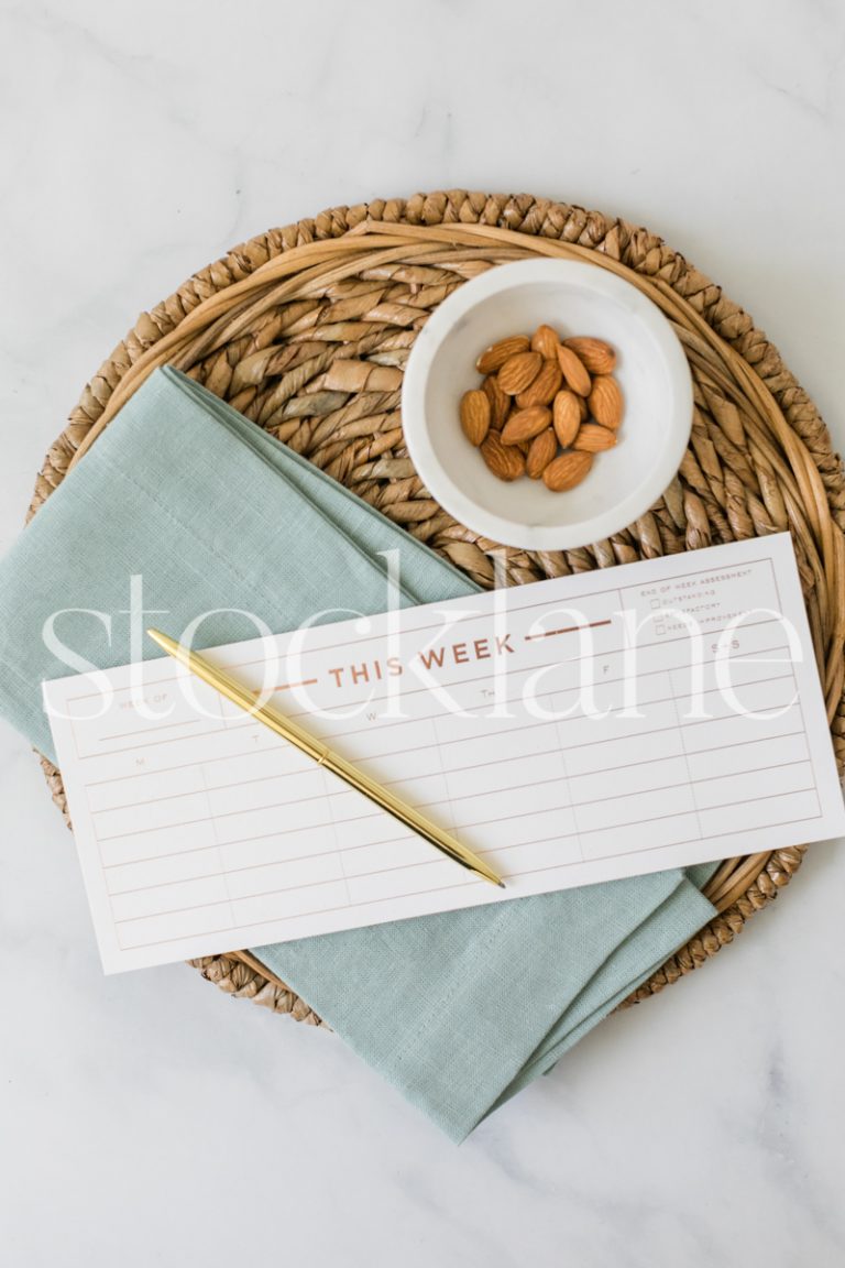 Vertical stock photo of a weekly planner and a bowl of almonds