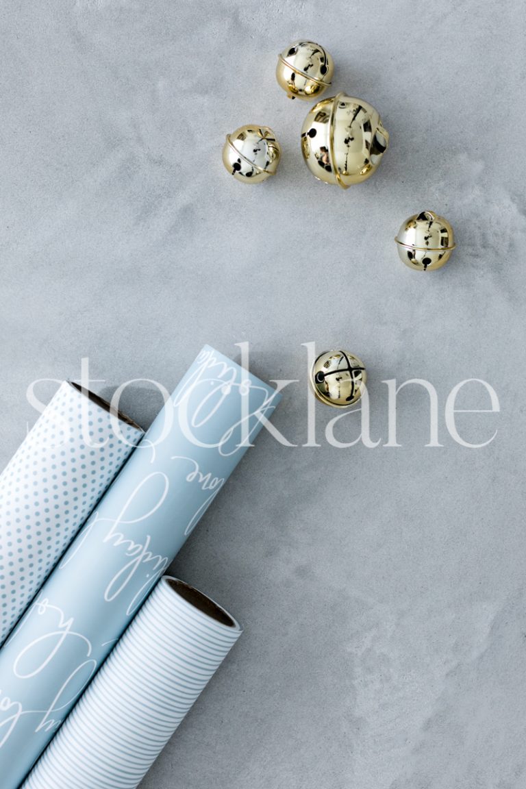 Vertical stock photo of light blue Christmas wrapping paper and bells