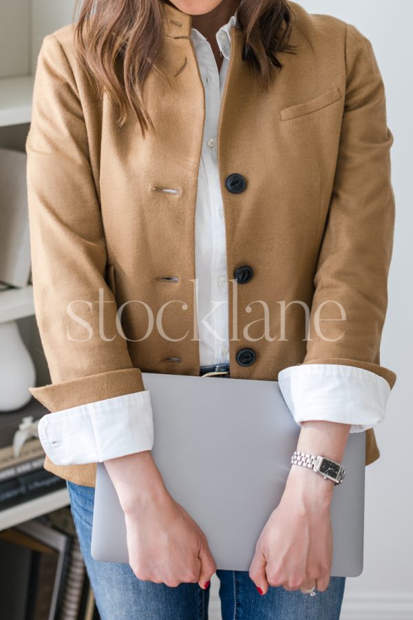 Vertical stock photo of a woman holding a laptop computer.