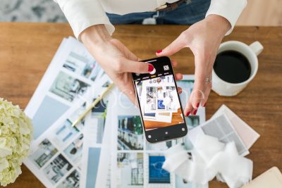 Horizontal stock photo of a woman taking a photo with her phone.