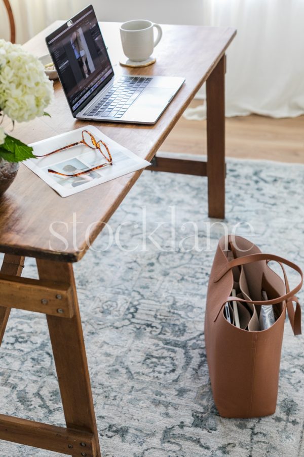 Vertical stock photo of a desk with a computer.