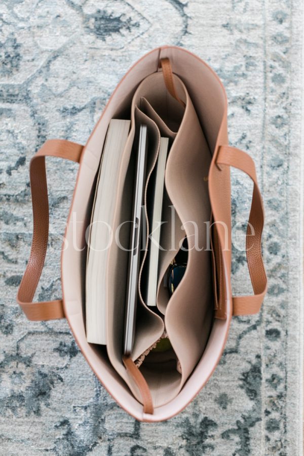 Vertical stock photo of a handbag with a computer.