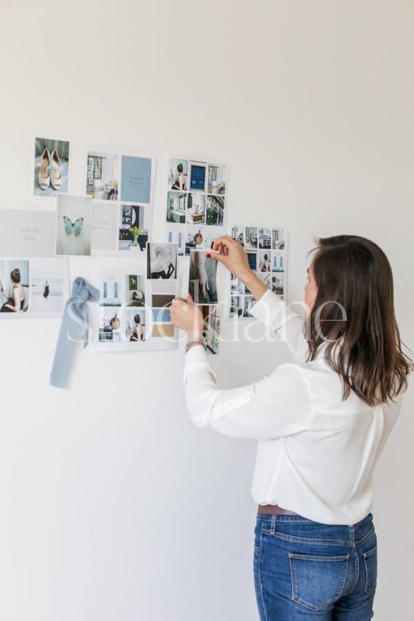 Vertical stock photo of a woman putting together a mood board.