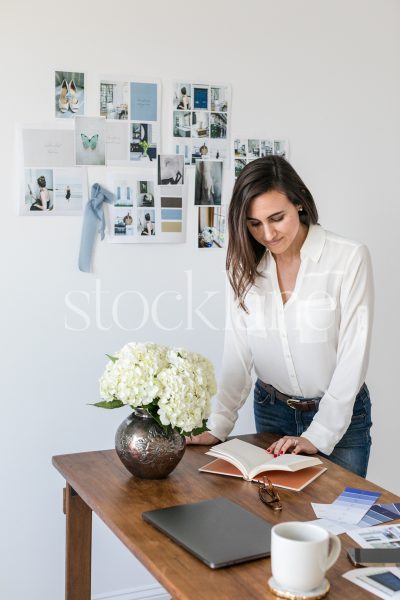 Vertical stock photo of a woman working at her desk.