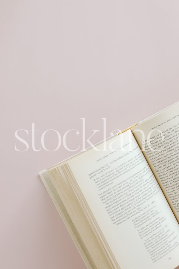 Vertical stock photo of a book on a pink background