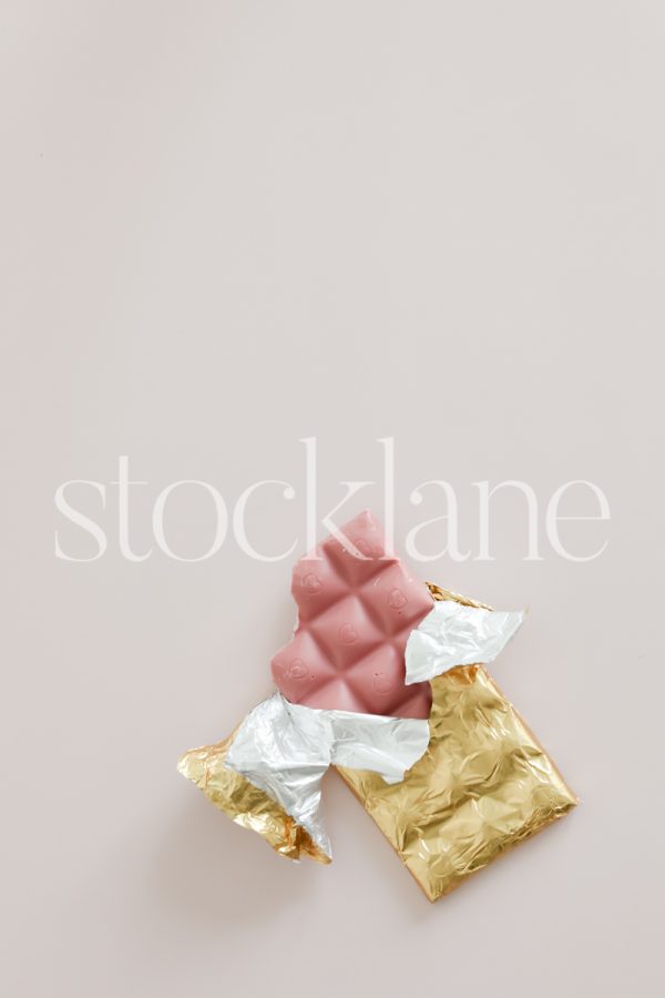 Vertical stock photo of a pink chocolate on a pink background