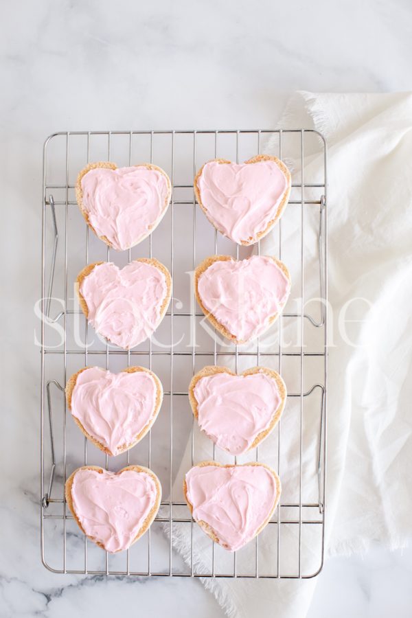 Vertical stock photo of heart-shaped cookies with pink frosting