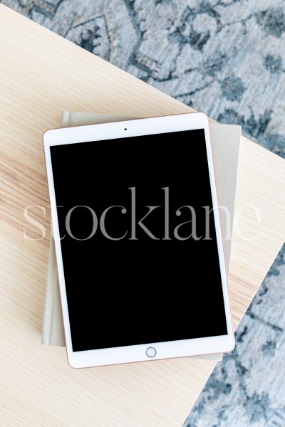 Vertical stock photo with an overview of an iPad on a table in neutral colors.