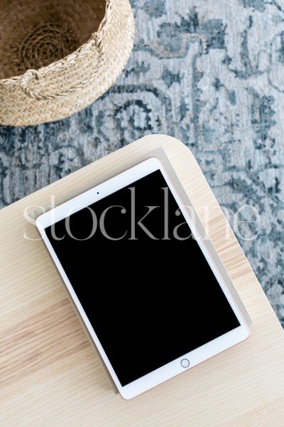 Vertical stock photo of an iPad on a neutral color table.