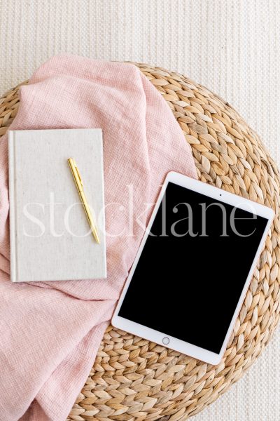 Vertical stock photo of a tablet mockup in pink and neutral colors.