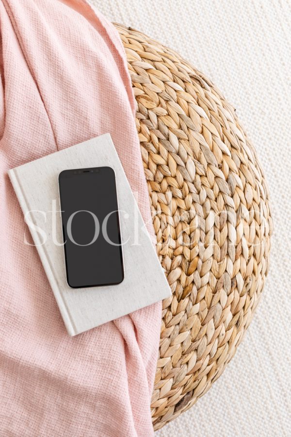 Vertical stock photo of a phone mockup in neutral and pink colors.