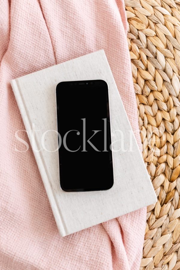 Vertical stock photo of a phone mockup in neutral and pink colors.