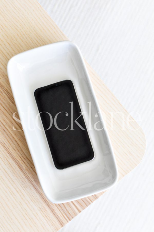 Vertical stock photo of a phone mockup in neutral colors.